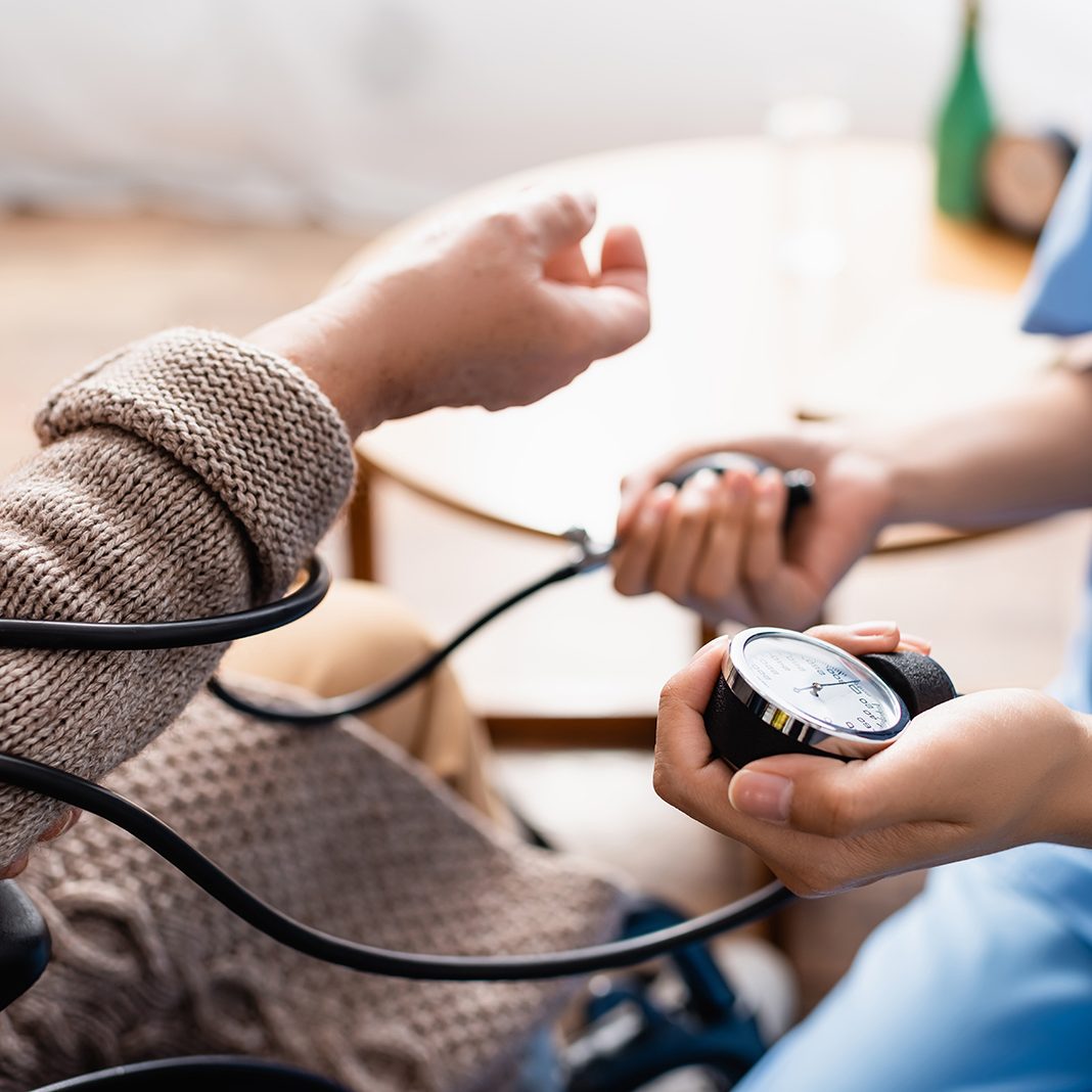 close up of a nurse checking blood pressure in a home